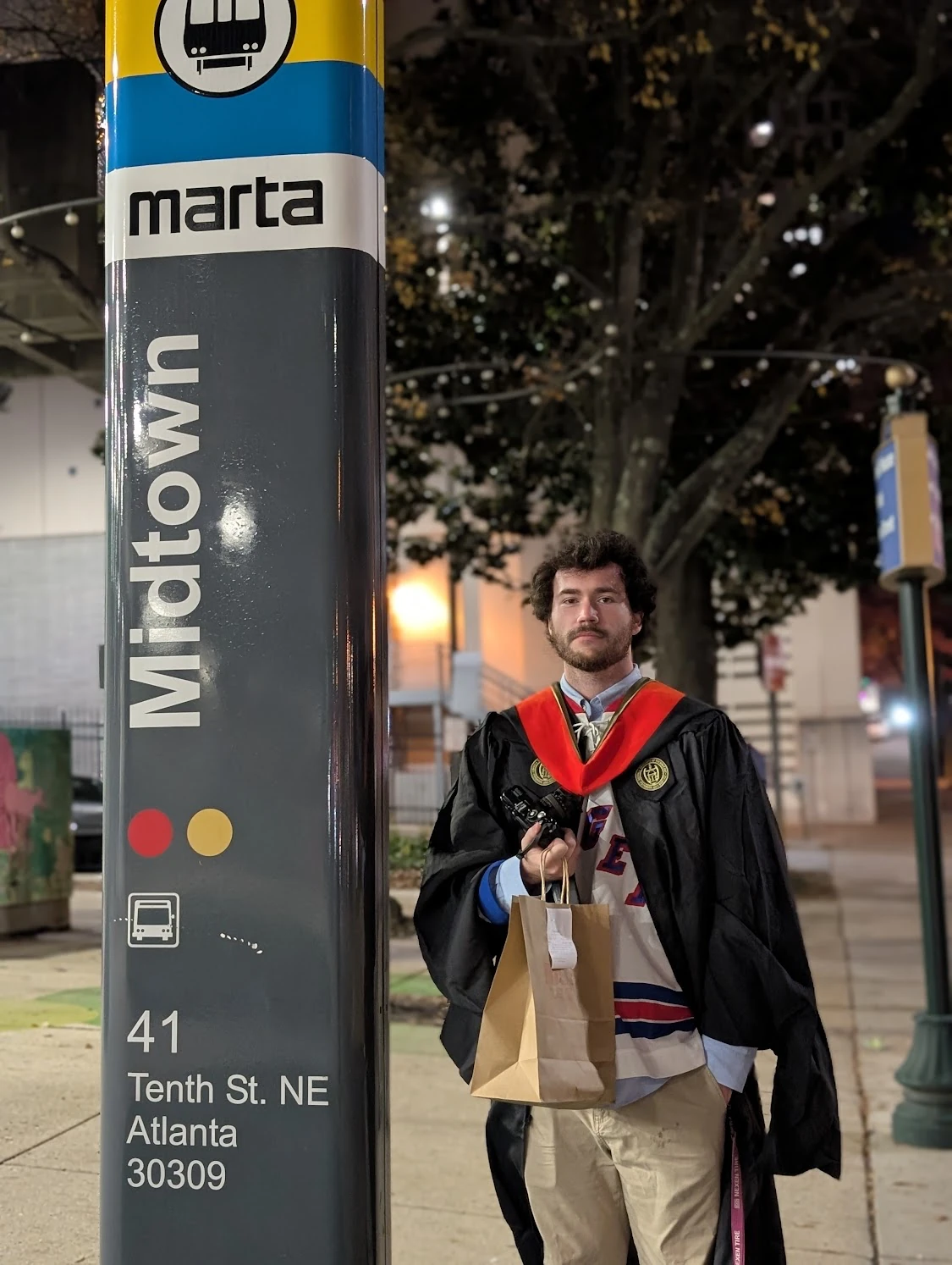 A picture of me in my master's regalia over a New York Rangers jersey.